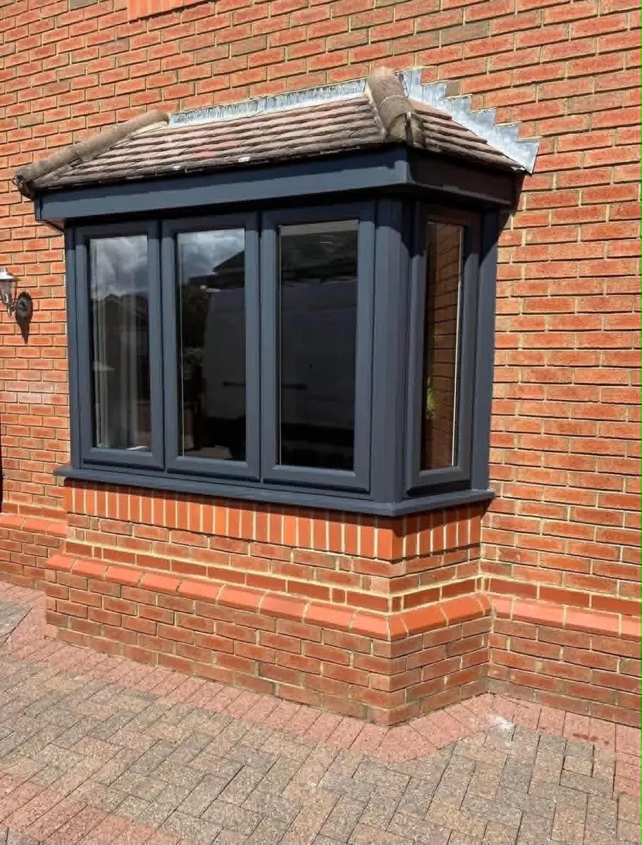 Black bow window fitted to a brick home